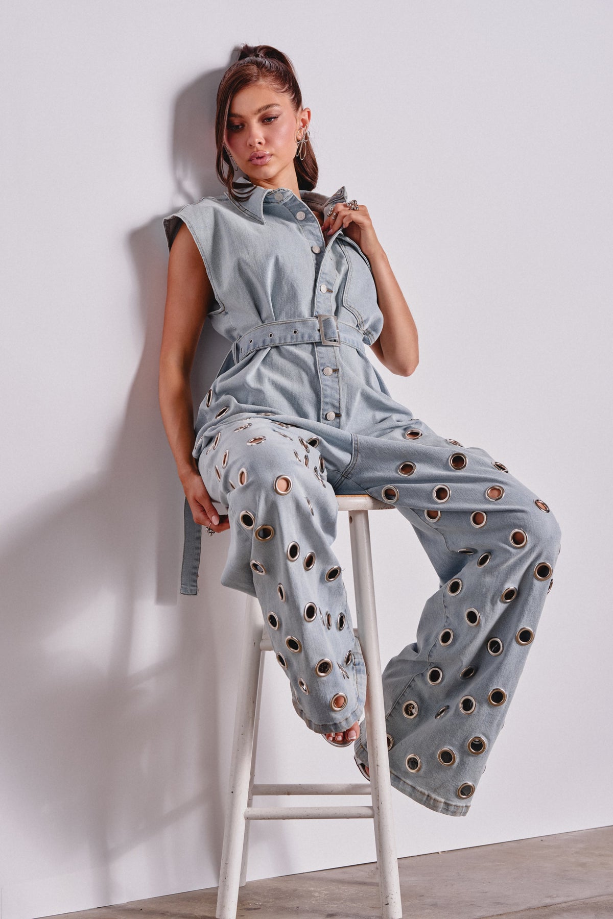 PLAY YOUR CARDS RIGHT DENIM JUMPSUIT WITH GROMMETS IN LIGHT WASH