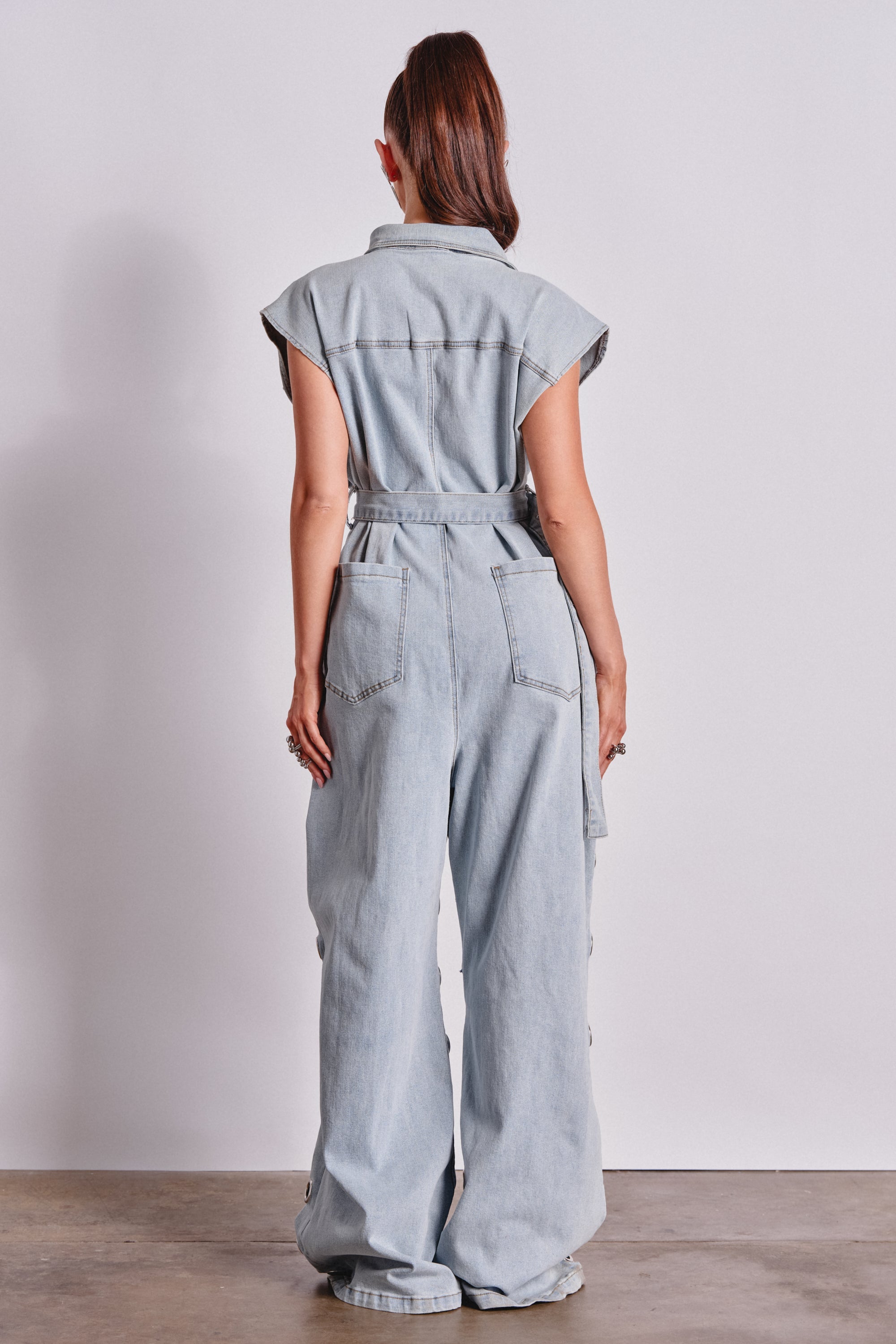 PLAY YOUR CARDS RIGHT DENIM JUMPSUIT WITH GROMMETS IN LIGHT WASH