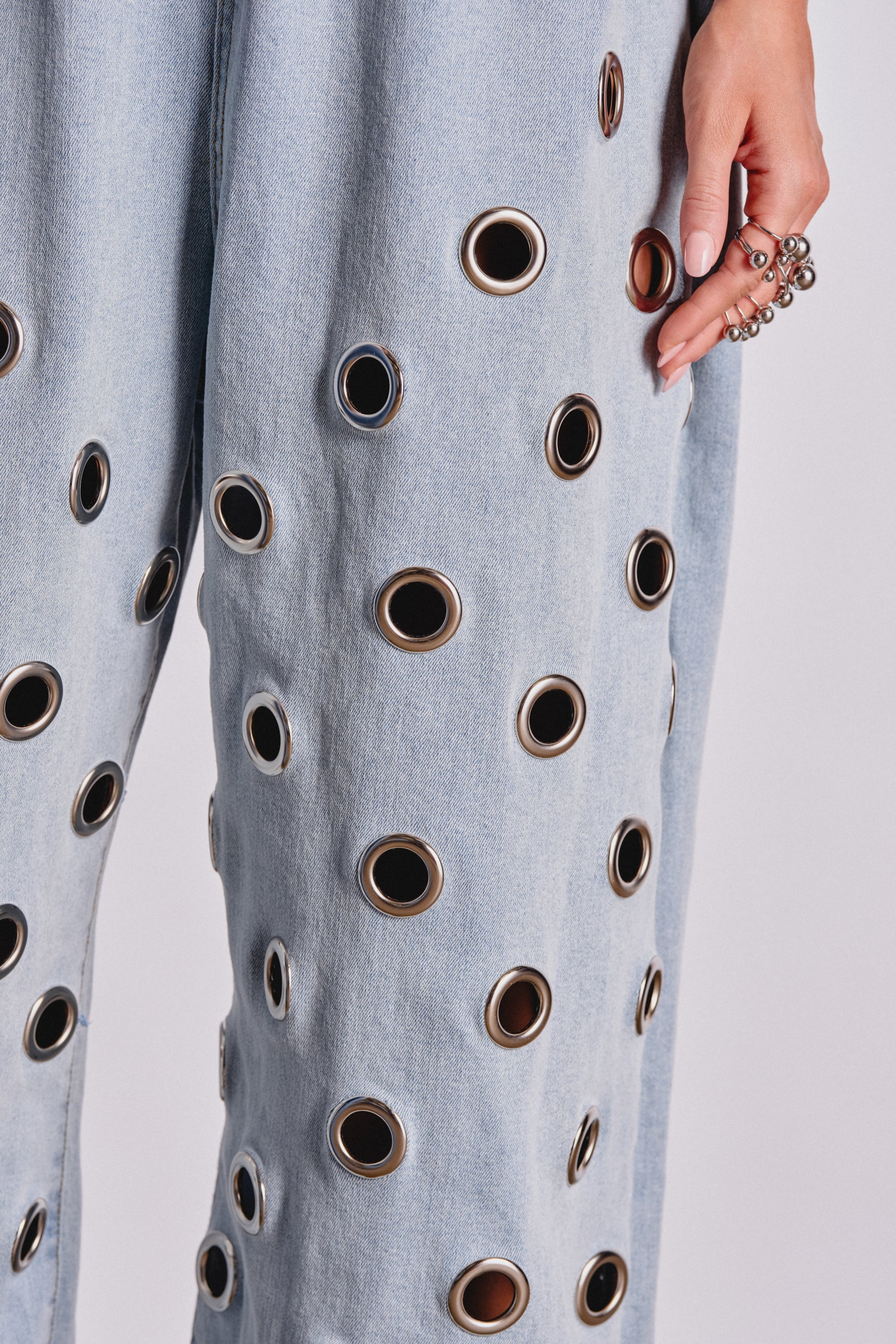 PLAY YOUR CARDS RIGHT DENIM JUMPSUIT WITH GROMMETS IN LIGHT WASH